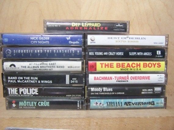 Gestapelte Musikkassetten mit Rock- und Pop-Alben auf Holztisch